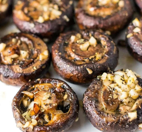 Baked garlic mushrooms arranged on a white plate